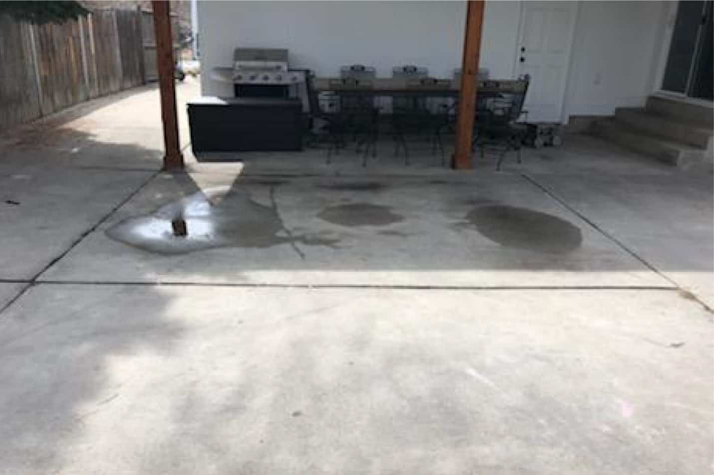 Outdoor concrete patio with water stains and grilling area at Landmark Lifting.